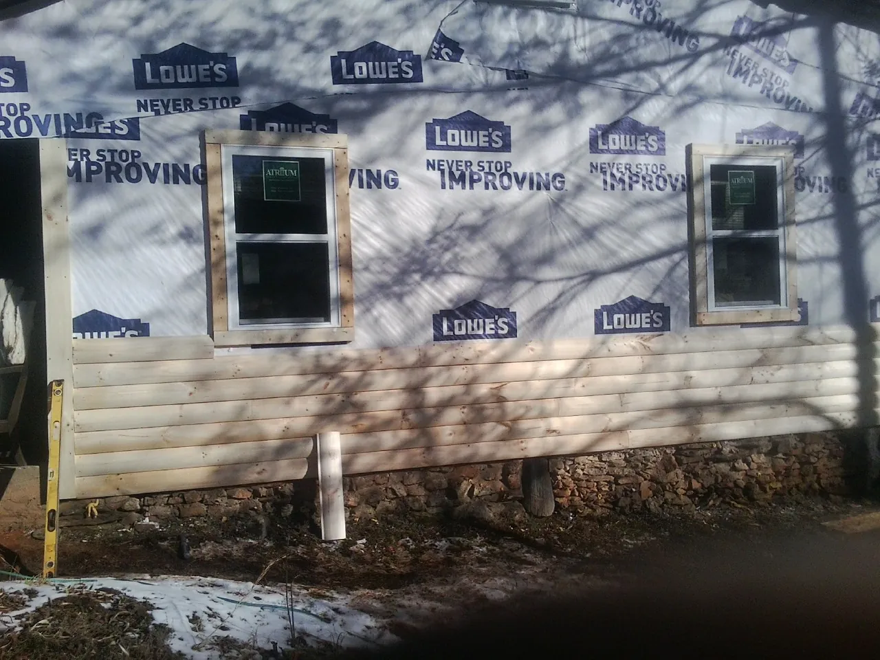 House wrap and new log siding going up on an exterior wall in Bremo Bluff