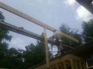 Carpenter setting a ridge beam over a new addition frame — Ice Dam Removal by Roofing Brothers in Bremo Bluff