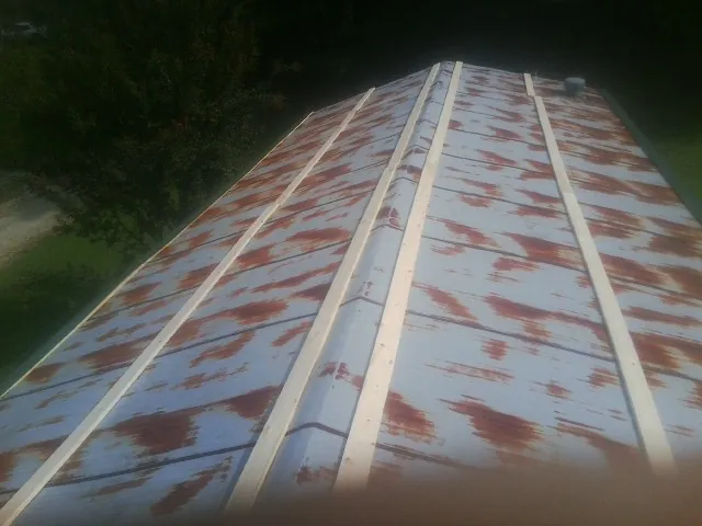 Rusted metal roof panels with new wood purlins before replacement — Storm Damage Roof Repair in Bremo Bluff by Roofing Brothers